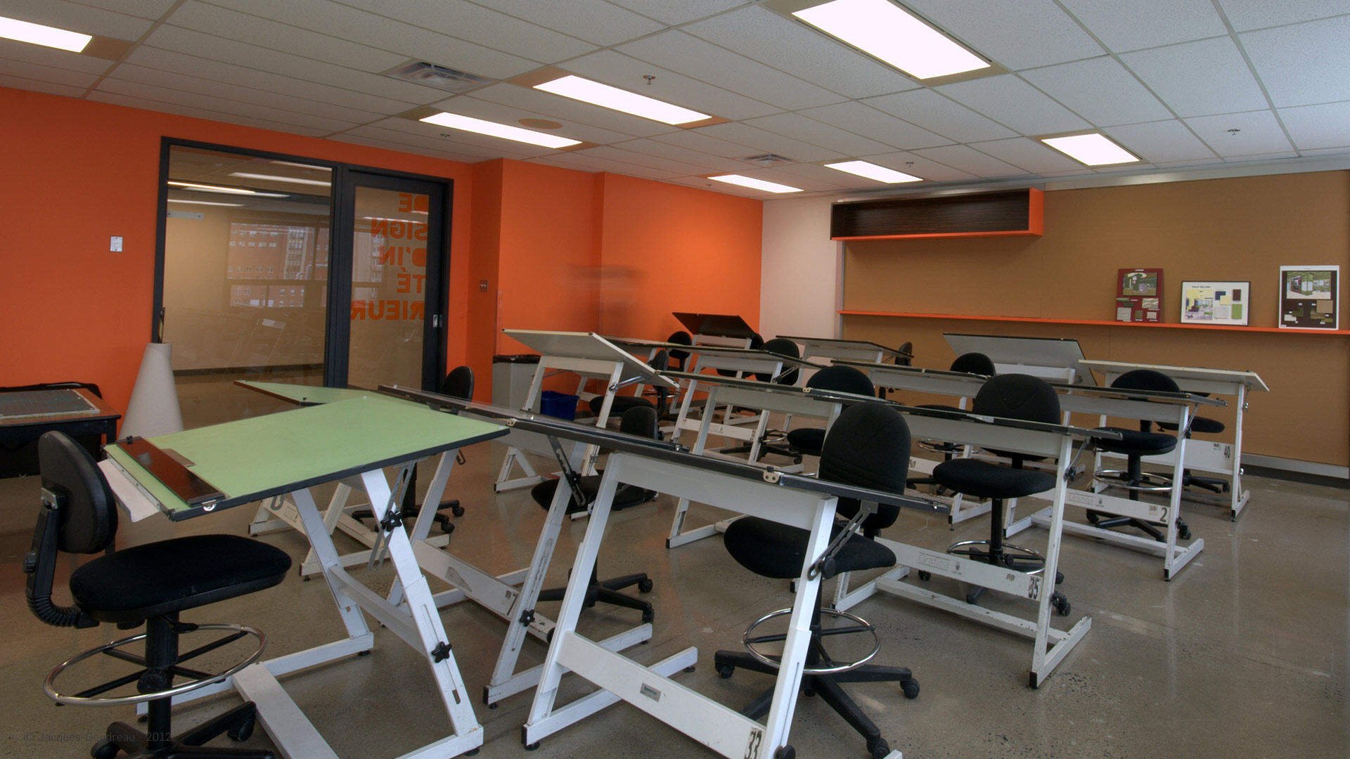 An educational drafting room with drawing boards and stools, empty and ready for an art class.