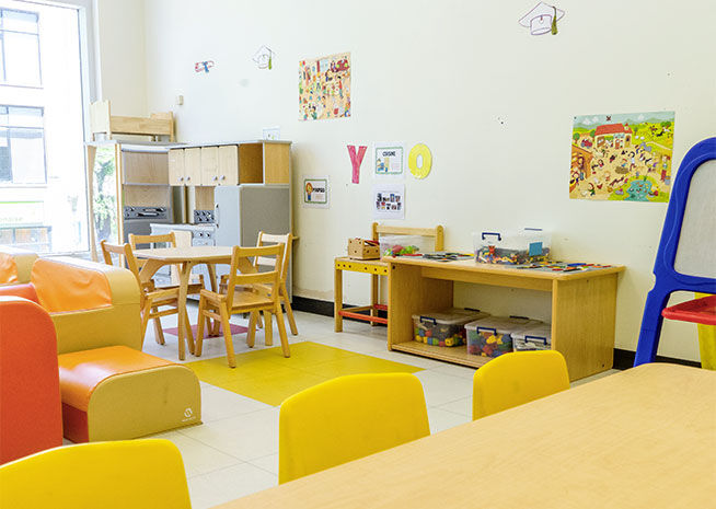 Une salle de classe maternelle vibrante avec des meubles colorés, des jouets éducatifs et un décor adapté aux enfants. L'espace est conçu pour être stimulant et engageant pour les jeunes apprenants.