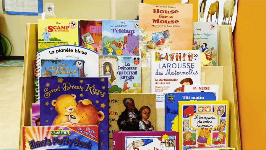 A bookshelf filled with a variety of colorful children's books in a classroom setting.