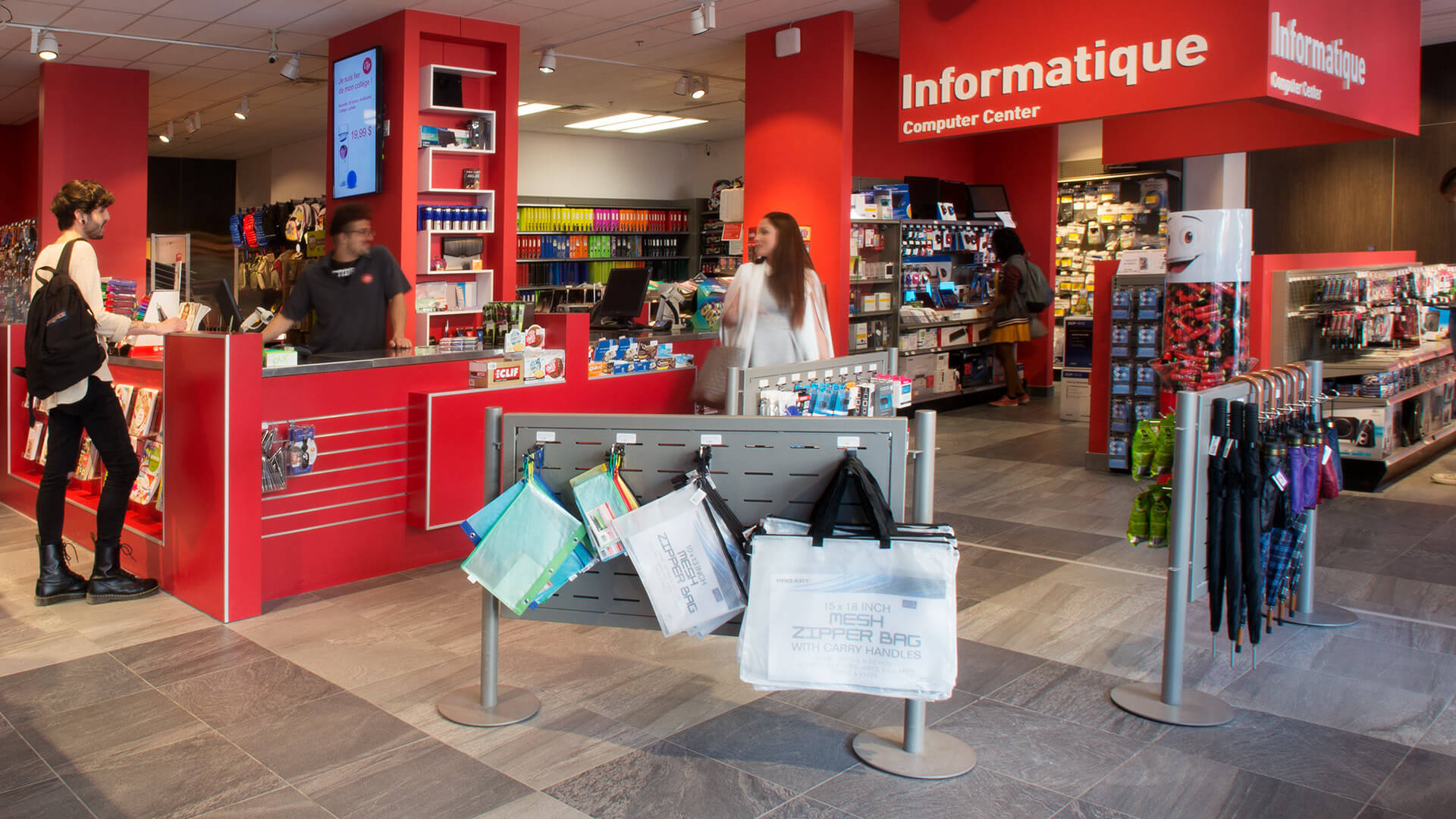 Customers browse products in a well-organized electronic store with vibrant red decor.