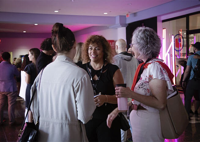 Les participants interagissent lors d'un événement social, s'engageant dans des conversations et du réseautage dans une atmosphère détendue.