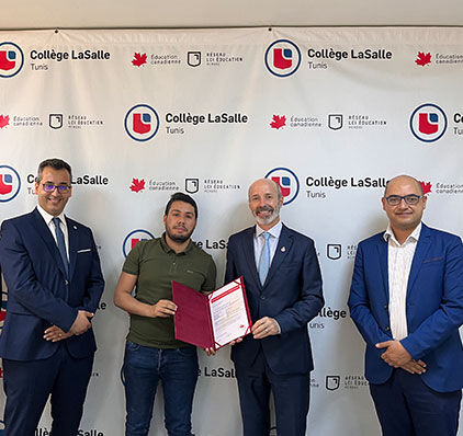  Quatre hommes, dont un tenant un certificat, posent au Collège LaSalle de Tunis, célébrant une réussite académique ou un partenariat.