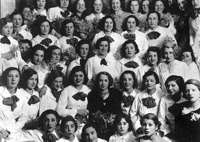 Fotografia històrica en blanc i negre d'un gran grup de dones amb vestimenta formal i corsatges.