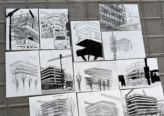 A collection of detailed architectural drawings pinned against a brick wall, showcasing various building designs.