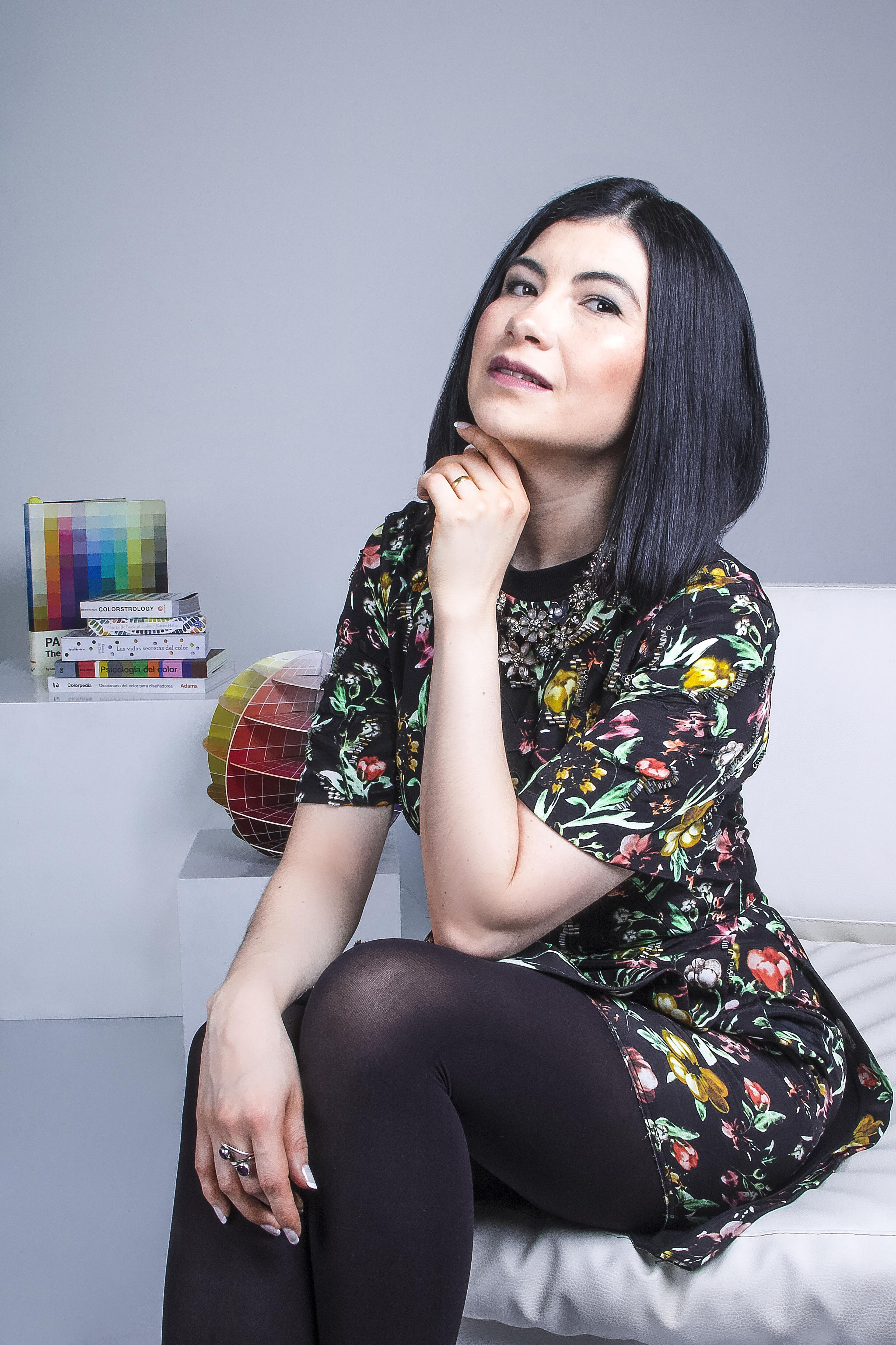 Woman in Floral Dress Sitting in a Modern Setting