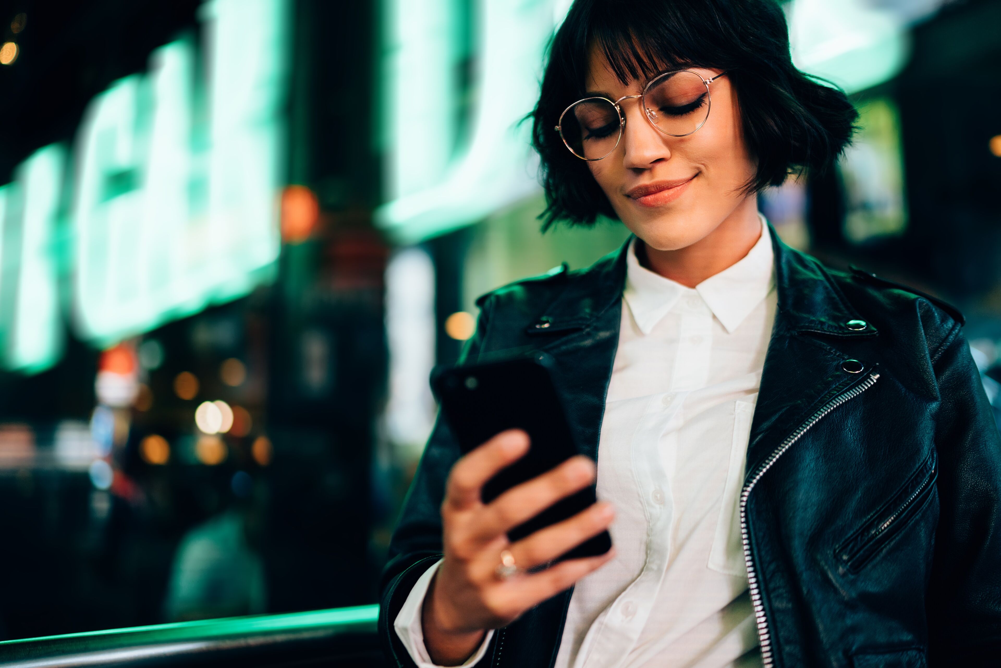 Mujer usando smartphone en la ciudad de noche