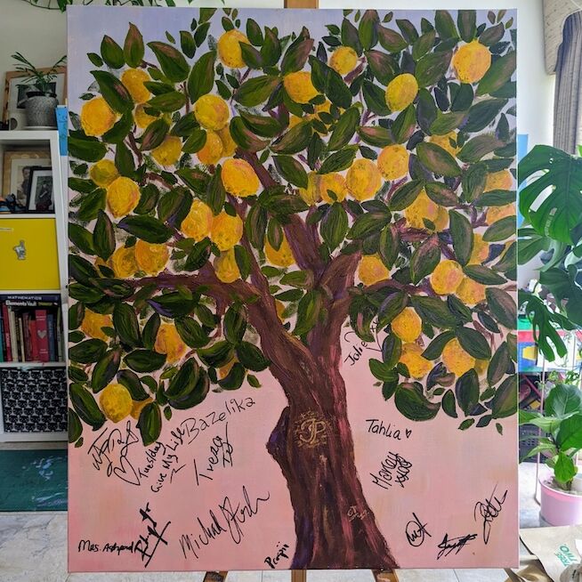 A vibrant painting of a lemon tree, adorned with signatures at the base, symbolizing collective creativity.