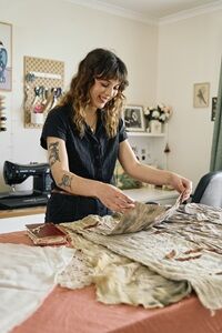 An artist with a joyful touch weaves life into textiles, in a space where creativity flows as freely as the fabric.