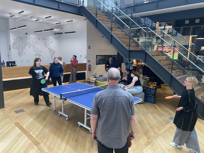 A casual ping-pong match unfolds, infusing life into the modern workspace.