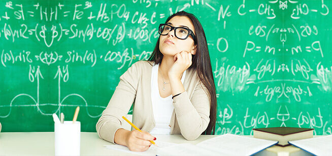 Una estudiante reflexiona sobre ecuaciones matemáticas complejas en una pizarra, mostrando la intensidad y el enfoque requeridos en la educación superior.